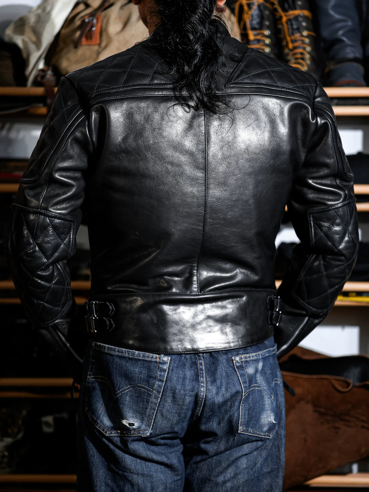 Rear three-quarter view of the MALLORY IMOLA racing jacket with quilted upper sleeves and side buckle adjusters
