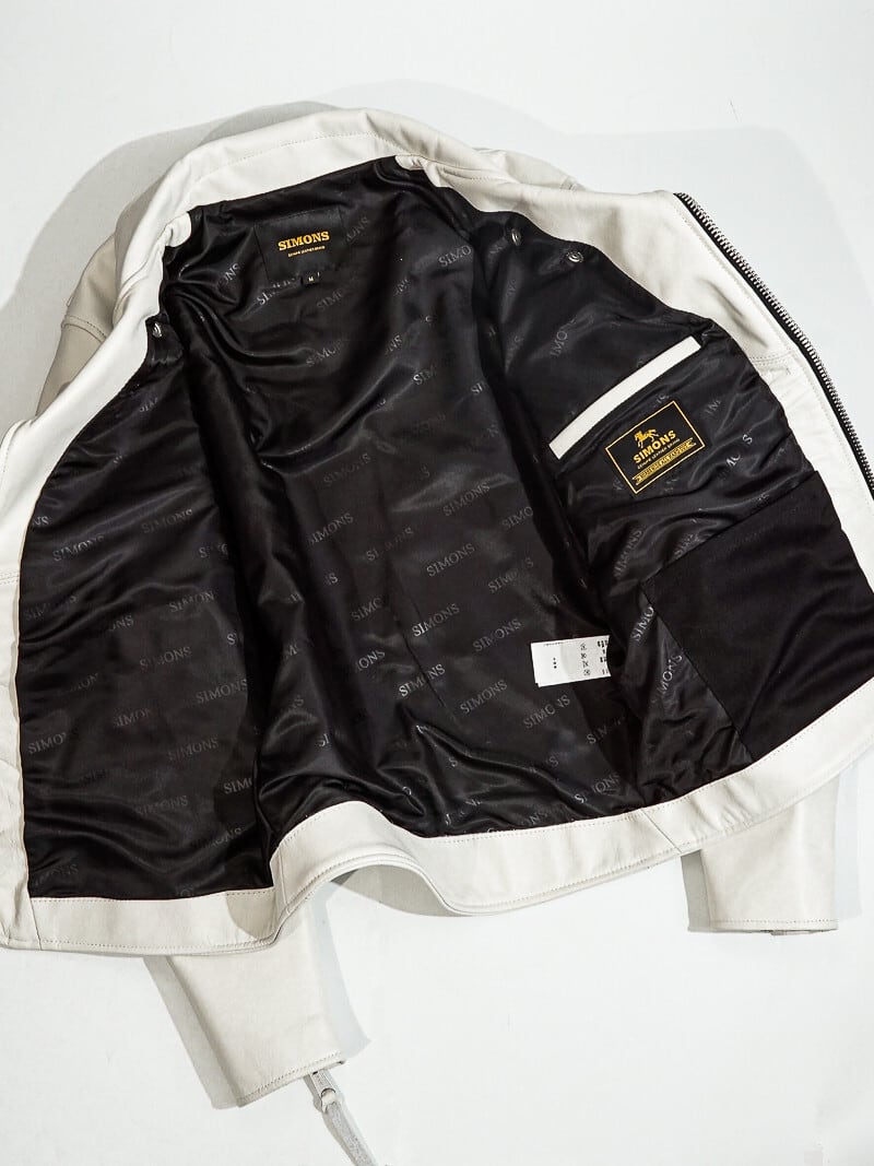 Inside of white riders jacket showing black SIMONS jacquard lining