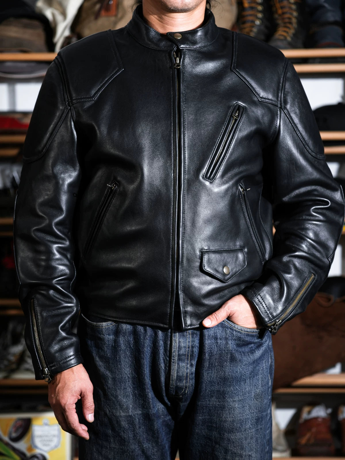 BRIXTON jacket in black sheepskin worn on model, close-up of front pockets and zipper