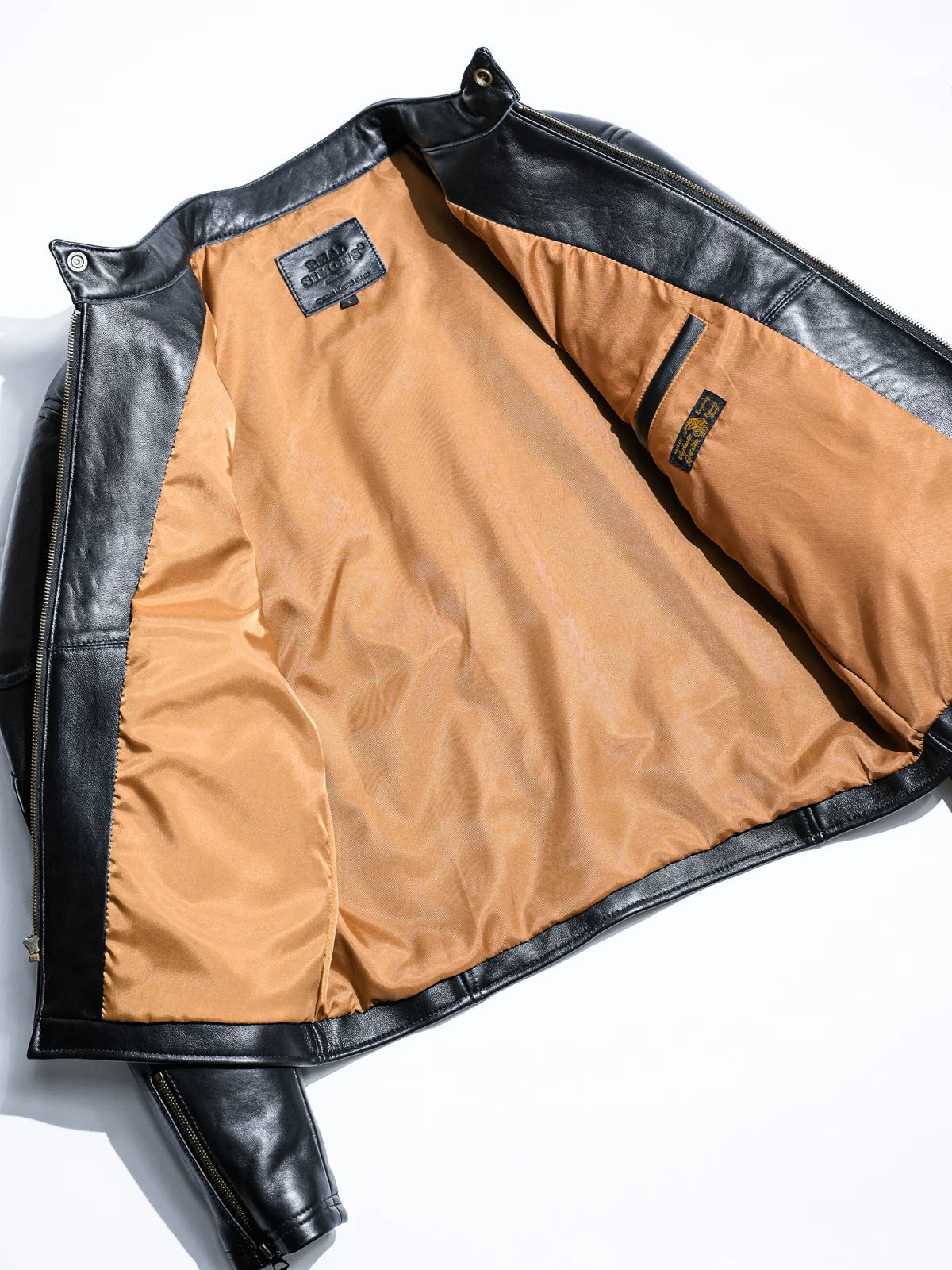 Inside of BRIXTON black jacket with light camel lining and Real Simons label