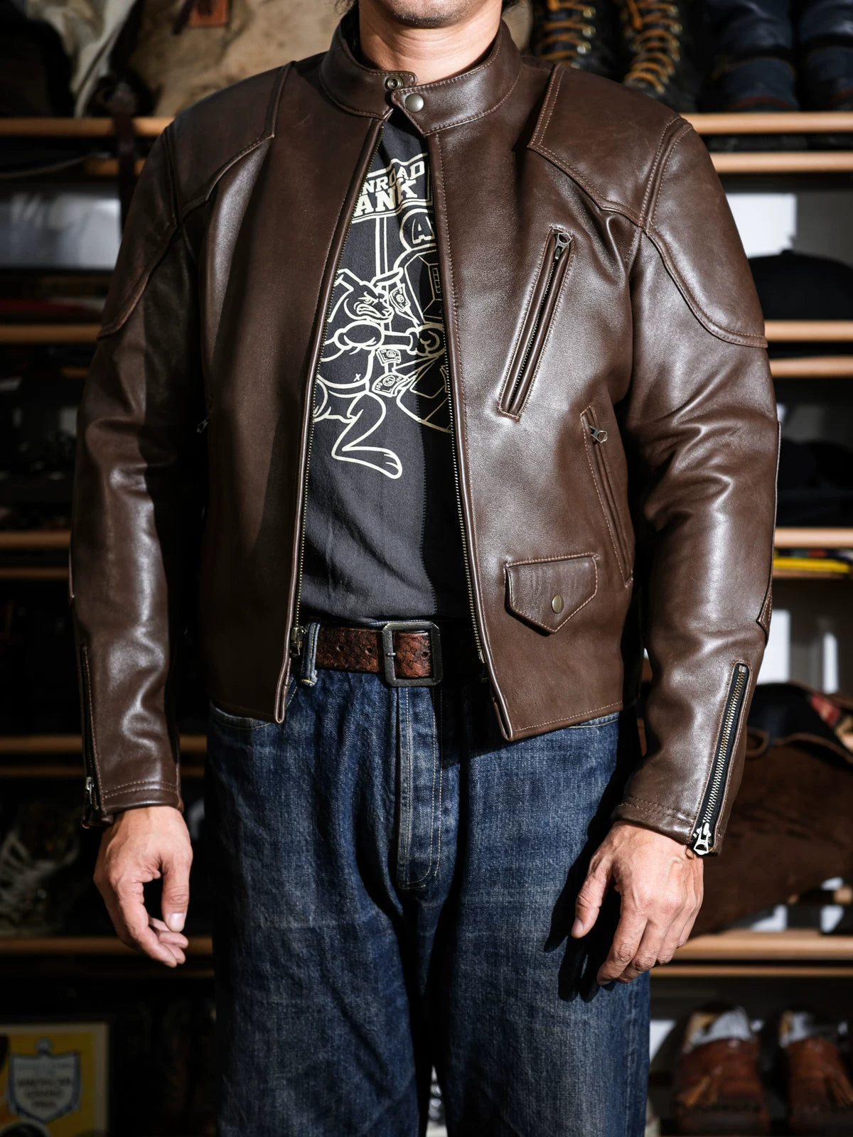 BRIXTON café racer jacket in dark brown tea-core sheepskin worn with denim, front view