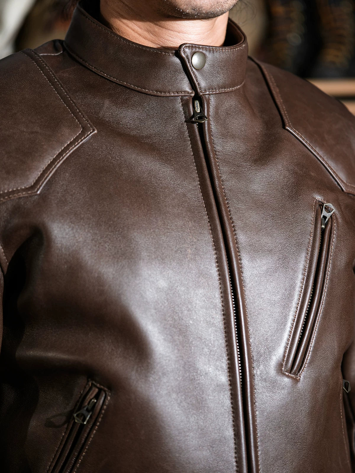 Close-up of BRIXTON brown jacket chest, collar and zip pockets