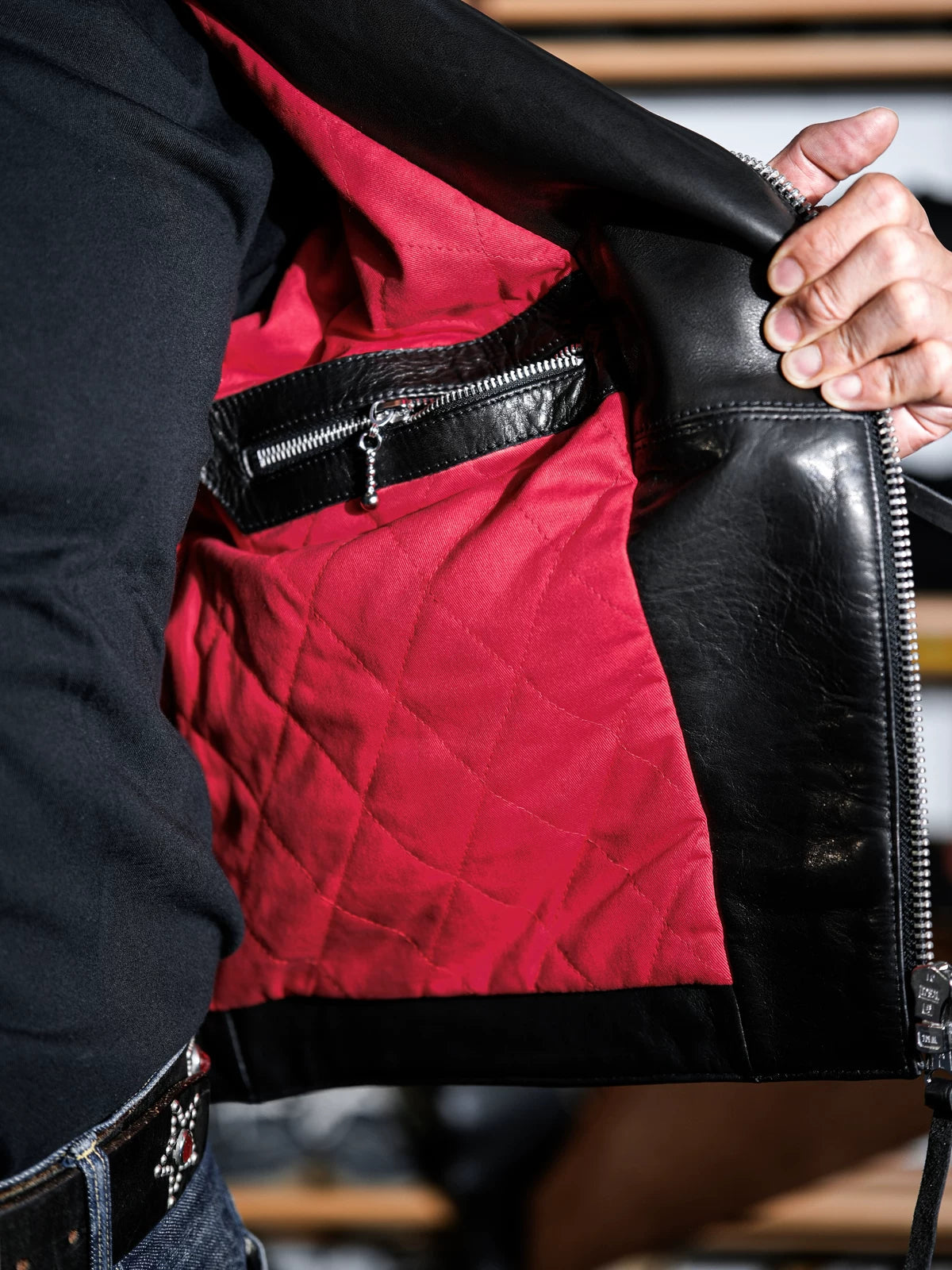 Inside of the MALLORY IMOLA jacket showing the red diamond-quilted lining and interior zippered leather pocket