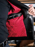 Inside of the MALLORY IMOLA jacket showing the red diamond-quilted lining and interior zippered leather pocket
