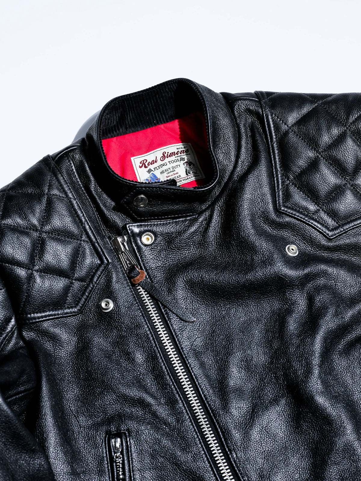 Close-up of the MALLORY IMOLA label and leather-tab zipper pull