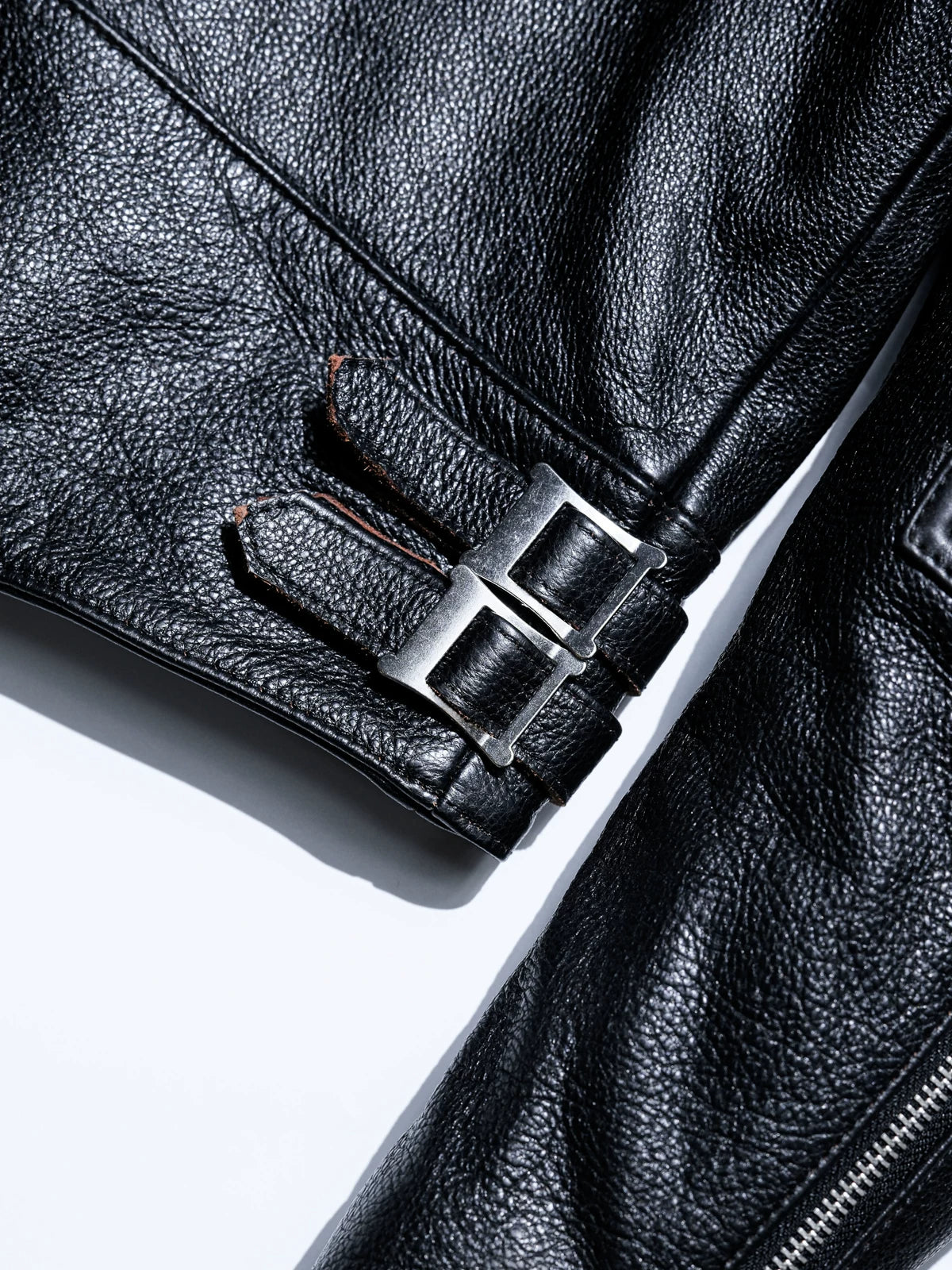 MALLORY IMOLA double-snap leather adjuster strap with metal buckles, brown core visible at the edges