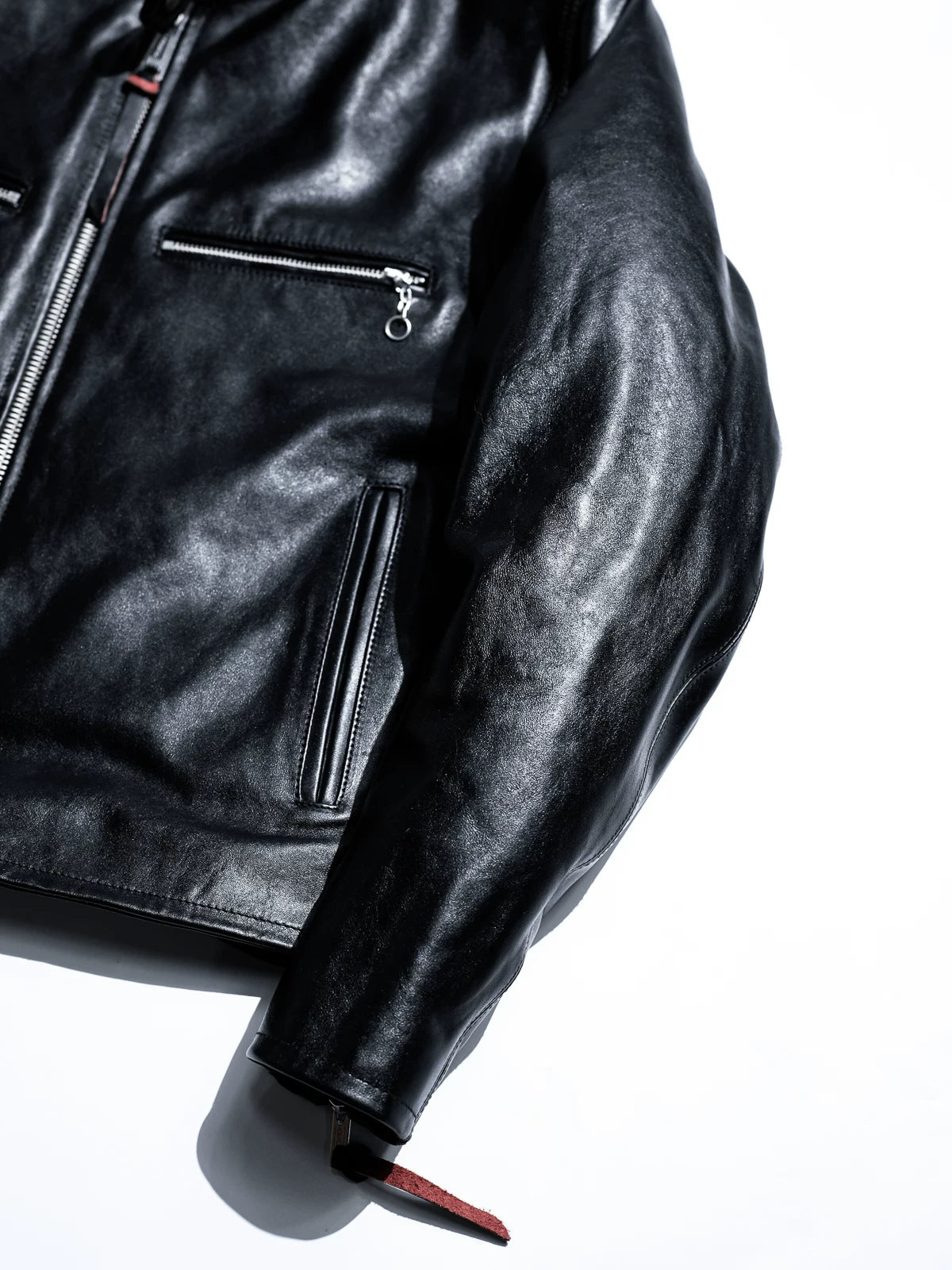 Mojave jacket sleeve, chest pocket and hem zip detail with red leather tail