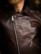 Close-up of engraved antique zipper pull and lapel edge on seal brown horsehide