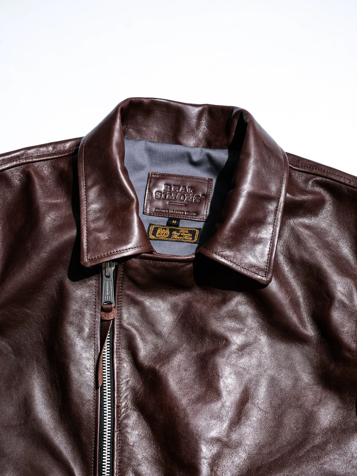 Flat lay stand collar with diagonal engraved zipper pull on chestnut seal brown horsehide