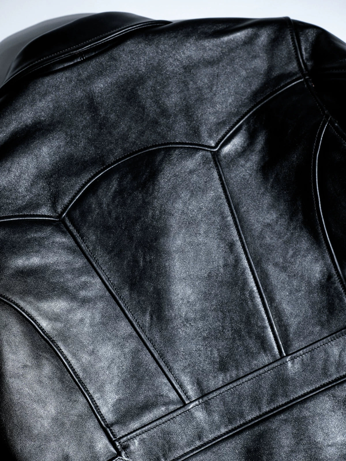 Parachute back yoke panel stitching close-up on black horsehide