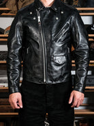 Black beltless riders jacket styled on model showing asymmetric zip and pockets