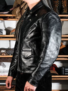 Side view of black riders jacket with snap pockets and work-wear styling