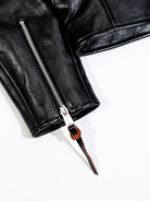 Black jacket cuff zipper detail with leather pull