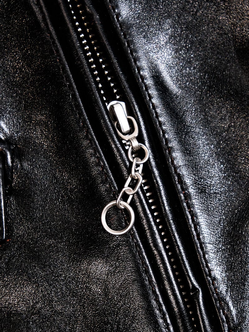 Black jacket pocket zipper with chain-style pull and ring