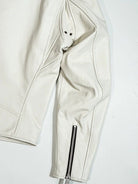 White jacket shoulder and sleeve detail with eyelets and cuff zipper