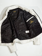 Inside of white riders jacket showing black SIMONS jacquard lining
