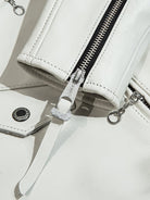 White jacket snap button and zipper detail with leather pull