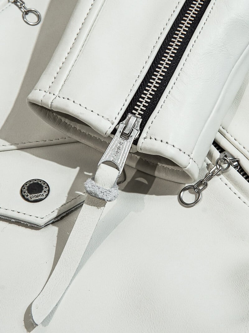 White jacket snap button and zipper detail with leather pull